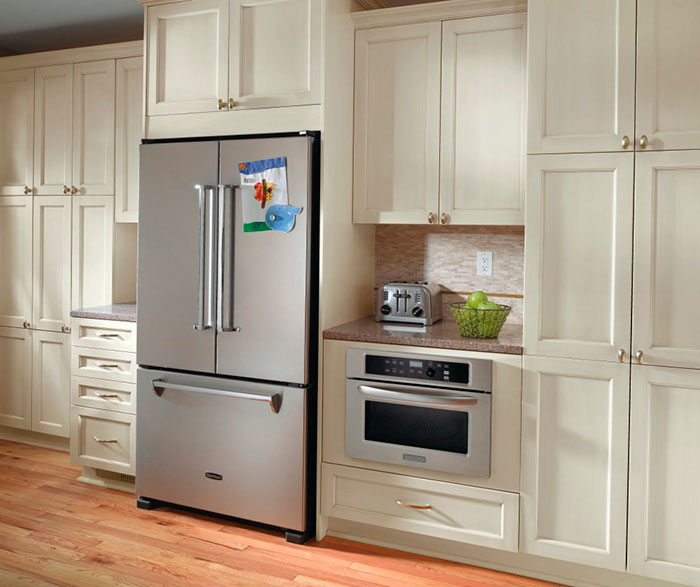 Off white cabinets in casual kitchen by Kitchen Craft Cabinetry